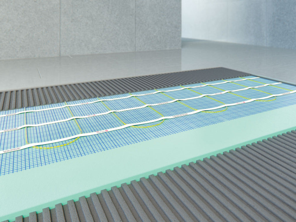 Underfloor heating system diagram showing a blue grid floor mat with white and yellow heating pipes, layered over a light green insulation board and finished with a dark gray ribbed protective cover.
