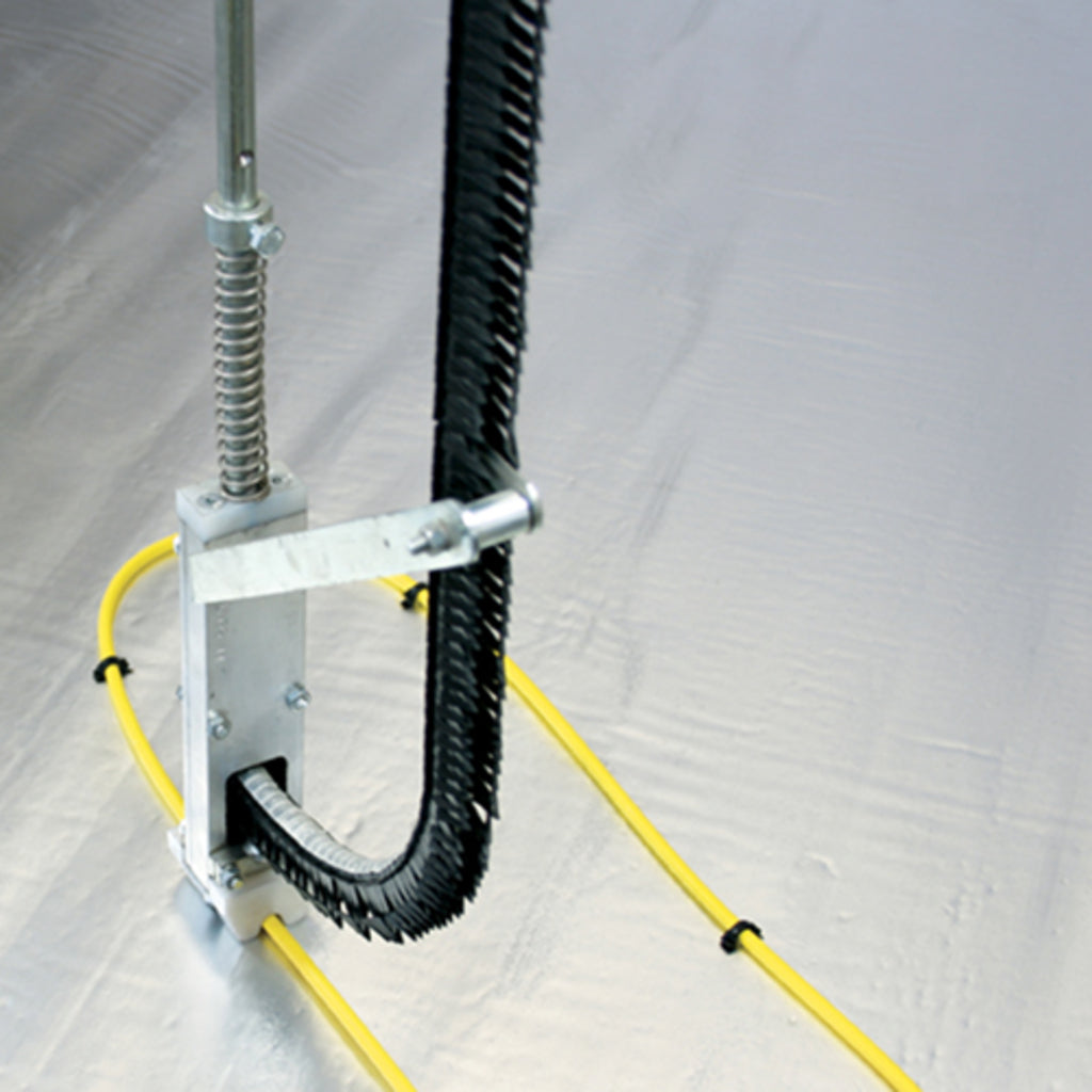 Fixing tool placing the ThermoSphere Screed Cable Staples onto a yellow heating cable to fix it onto xps insulation board.